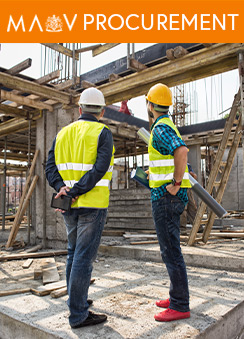 A photograph of two workmen looking at a building under construction