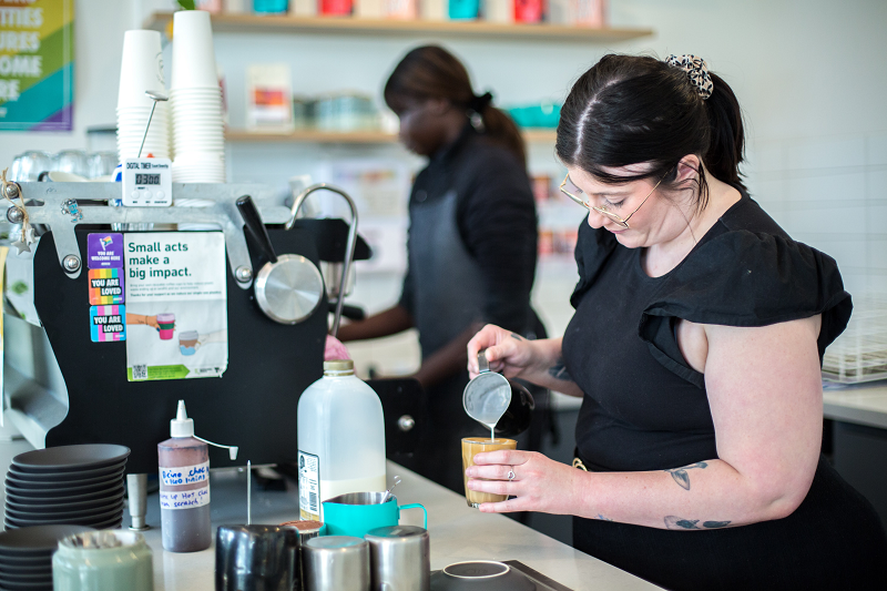 Woman pouring coffee in cafe