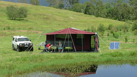 Tent and 4WD and solar panel in a grassy field